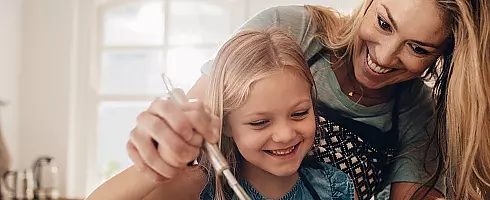 moeder en dochter in de keuken lachen